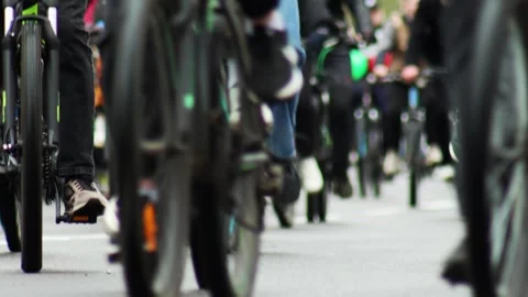 Large group of cyclists riding bicycles on a paved road, close-up view of Stock Footage 340386764