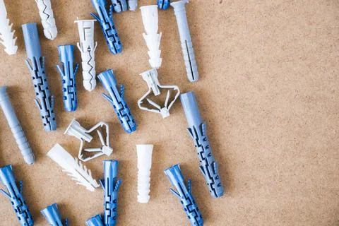 Large group of different plastic wall plugs on the brown background Foto stock