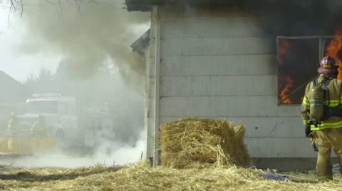 Large group of firemen crouch outside a burning house Stock Footage 60959363