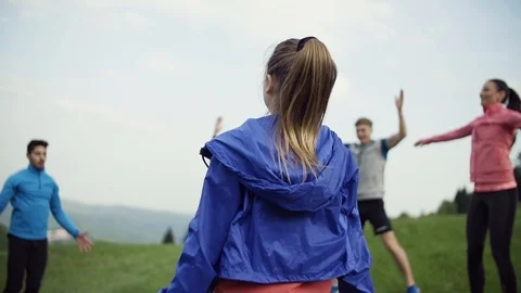 Large group of fit and active people doing exercise in nature. Slow motion. Stock Footage