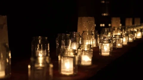 Large group of glass jars with burning candles on the dark background Stock Footage 83084814