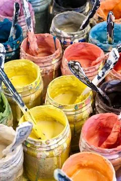 Large group of open cans of multi-colored paints Stock Photos