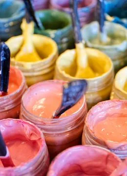 Large group of open cans of multi-coloured paints Stock Photos