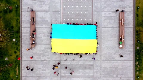 A large group of people hold the Flag of Ukraine in the city square. Patriotic Video stock 186081926