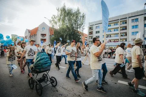 A large group of people walking through a city neighborhood. 스톡 사진