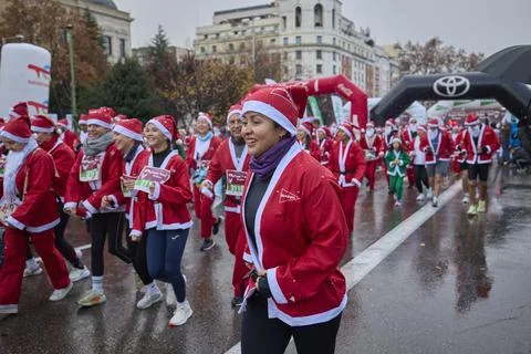 Large group of runners dressed as Santa Claus during Christmas charity run Stock Photos
