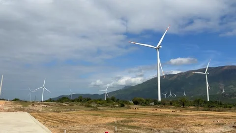 A large group of wind power turbines rotates simultaneously across rural land Stock Footage 330662832