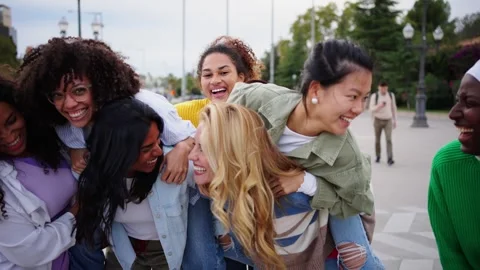 Large group of young multiracial only women friends piggyback looking laughing Stock Footage 316923507