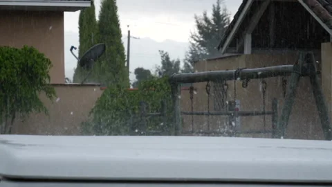 Large hail stones bouncing off a car roof in slow motion Stock Footage 168049404