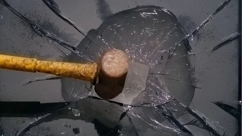 A large hammer shatters the TV screen, splinters fly apart. Slow Motion Video Stock Footage 81555359