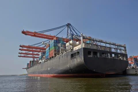 Large harbor cranes loading container ships in the port of Rotterdam Stock Photos