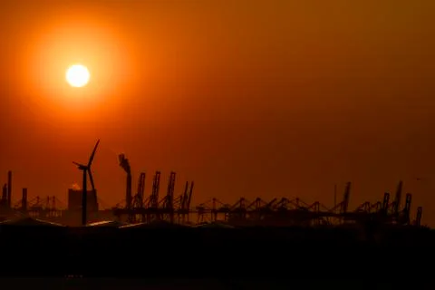 Large harbor cranes loading container ships in the port of Rotterdam Stock Photos