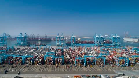 Large harbor cranes loading container ships in the port of Rotterdam Stock Photos