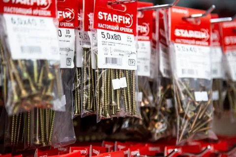 In a large hardware store on racks they weigh and stand nails and screws for Stock Photos