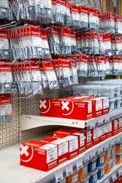 In a large hardware store on racks they weigh and stand nails and screws for Stock Photos