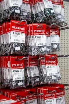 In a large hardware store on racks they weigh and stand nails and screws for Stock Photos