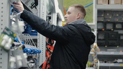Large hardware store. Young man in a hardware store. A man in a hardware store Stock Photos