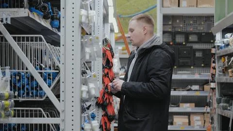 Large hardware store. Young man in a hardware store. A man in a hardware store Stock Photos