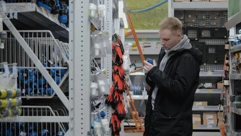 Large hardware store. Young man in a hardware store. A man in a hardware store Foto stock