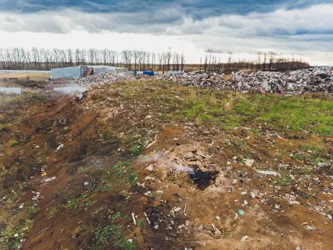 The large heap garbage dump extends parallel to the river,Garbage mountains with Foto stock