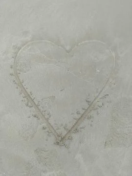 Large heart shape etched into smooth beach sand Stock Photos
