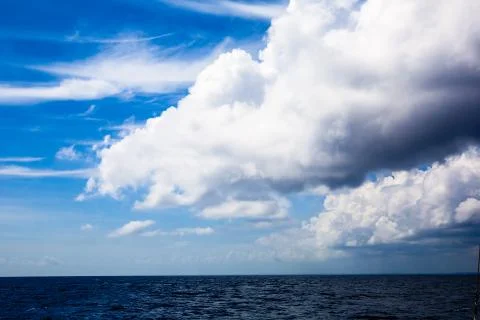 A large heavy cloud above the blue sea. Stock Photos