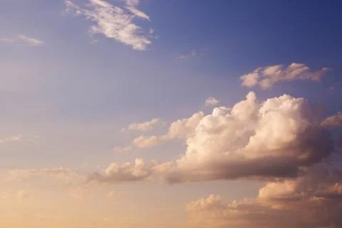 Large heavy clouds slowly float across the blue beautiful sky. Stunning Stock Fotos