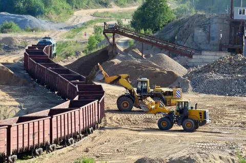 Large heavy front-end loader loading sand it to the freight train. Foto stock