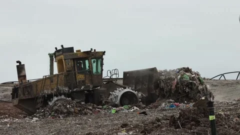 Large heavy plant and compactors moving recently tipped waste at walleys quarry Stock Footage 180090408
