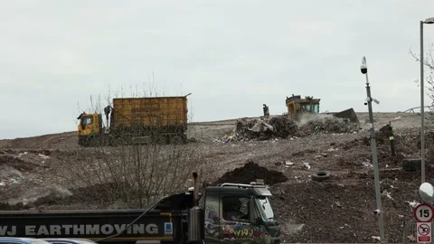 Large heavy plant and compactors moving recently tipped waste at walleys quarry Stock Footage 180090569