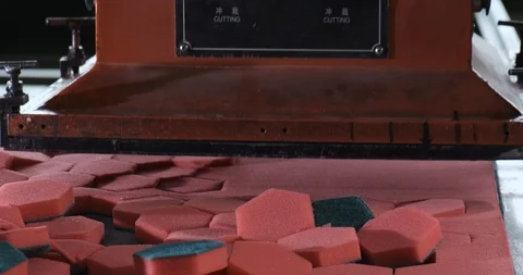 Large heavy press cuts red synthetic material into equal hexagons, soft sponge Stock Footage 128636144