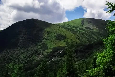 Large, high mountains with a stone on the background of wildlife and open sky Stock Photos