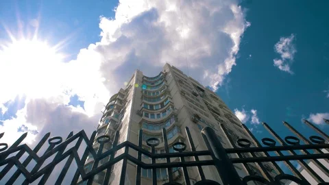 Large high-rise building on the background of flying clouds in sunny weather Stock Footage 128743867
