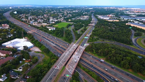 Large highway intersection surrounded by trees and a town. Two massive highways Video stock 347414553