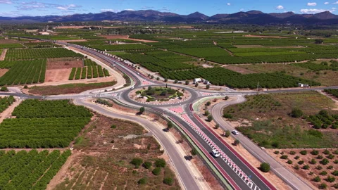Large highway roundabout interchange surrounded by green agricultural fields Stock Footage 341468672
