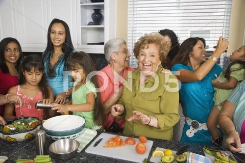 Large Hispanic family in kitchen preparing food Stock Photos