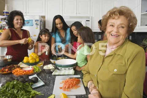 Large Hispanic family in kitchen preparing food Stock Photos
