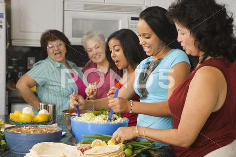 Large Hispanic family in kitchen preparing food Stock Photos