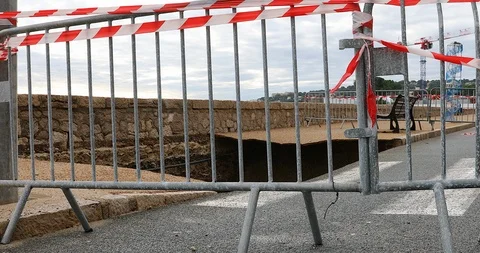 Large Hole In The Collapsed Sidewalk Behind Security Barriers 스톡 동영상 120352041