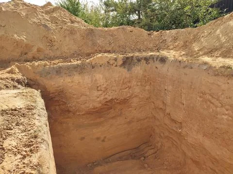 Large hole in the ground for a basement. Digging a hole. Building works of .. Stock Photos