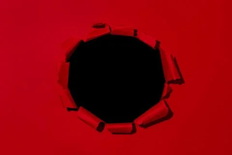 Large hole in red paper, empty space for advertising text in torn paper Stock Photos