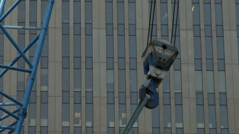 A large hook on a construction crane pulls a load it is attached to Stock Footage 96124555