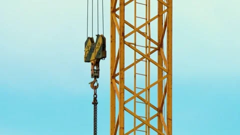 Large hook of a powerful tower crane. The hook on cables and pulleys sways in Stock Footage 303378326