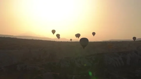 Large hot air balloon envelope silhouettes hover at sunrise Stock Footage 149645207
