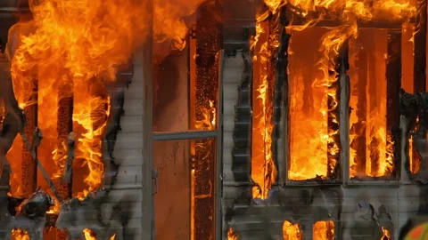 Large house fire ablaze with dangerous flames. Close up slow motion shot of a Stock Footage 229816852