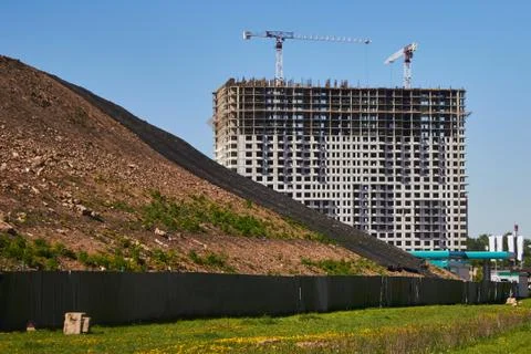 Large house under construction on the background of the landfill. Tower crane Stock Photos