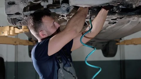 Large hydraulic jack. auto mechanic repairs the gearbox in a modern car.  Stock Footage 239471194