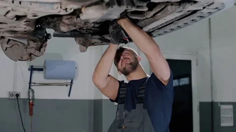 Large hydraulic jack. auto mechanic repairs the gearbox in a modern car. Stock Footage 239471327