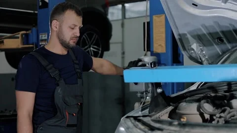 Large hydraulic jack. auto mechanic repairs the gearbox in a modern car.  Stock Footage 239471791