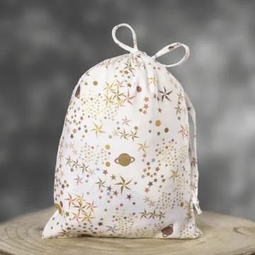 Large hygiene draw-string bag with colorful print, displayed on a wooden disc Stock Photos